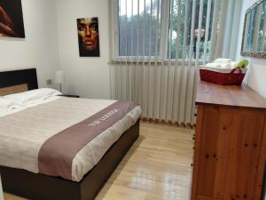 a bedroom with a bed and a wooden dresser at VIP Lounge in Settimo Milanese