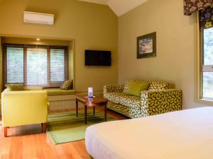 Pokój z łóżkiem, kanapą i stołem w obiekcie Freycinet Lodge w mieście Coles Bay