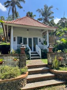 a small white house with a staircase leading to it at Bali Dreams Bungalows in Tenganan