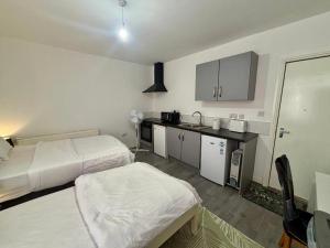 a small room with two beds and a kitchen at HomesRentals Studio in Dudley