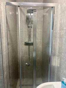 a shower with a glass door in a bathroom at HomesRentals Studio in Dudley