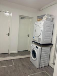 a washing machine sitting on top of a washer at HomesRentals Studio in Dudley