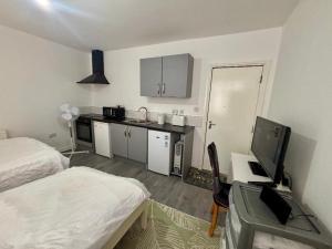 a small room with a bed and a desk with a computer at HomesRentals Studio in Dudley +14 photos