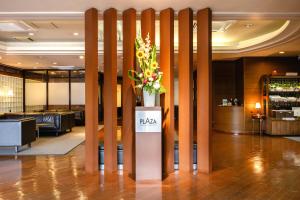 a lobby with a vase of flowers on a pillar at Hirosaki Plaza Hotel in Hirosaki