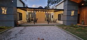 a house with a patio with chairs and a table at Cabañas MI REFUGIO TERMAL in Roboré