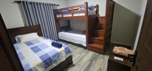 a small bedroom with a bunk bed and a small bed at Cabañas MI REFUGIO TERMAL in Roboré