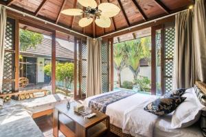 a bedroom with a bed and a table and windows at 三亚亚龙湾伊墅情怀旅租 in Sanya +48 photos