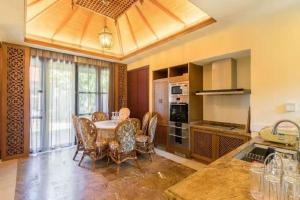 a kitchen with a table and chairs in a room at 三亚亚龙湾伊墅情怀旅租 in Sanya