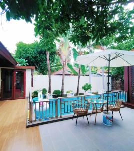 a patio with a table and an umbrella at 三亚亚龙湾伊墅情怀旅租 in Sanya