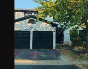 a house with two garage doors in front of it at Ivy Den in Oakville