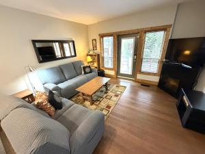 a living room with a couch and a table at Luxury Condo 2Bed, 1Bath, Pool, Hot Tub, Beach, Golf in Osoyoos
