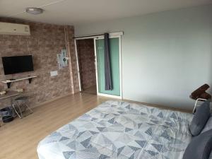 a bedroom with a large bed and a television at SLEEPY-Homey Don Mueang Airport Hostel in Bangkok