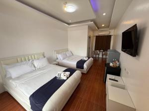 a hotel room with two beds and a flat screen tv at At The Pad Hotel & Villa's in Angeles