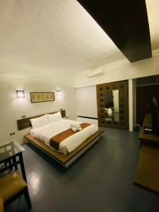a bedroom with a large bed and a mirror at At The Pad Hotel & Villa's in Angeles