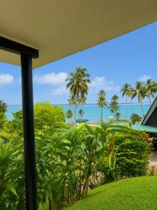 a view of the beach and palm trees from a house at Crusoe's Retreat - Family Friendly in Namanggumanggua