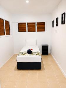 a bedroom with a bed in a white room at Crusoe's Retreat - Family Friendly in Namanggumanggua