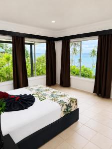 a bedroom with a bed with a view of the ocean at Crusoe's Retreat - Family Friendly in Namanggumanggua +118 photos