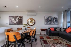 a living room with a table and chairs and a couch at Ocean Vista Pebble Beach in Umhlanga