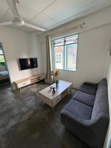 a living room with a couch and a tv at Stellas house in Langkawi Islands