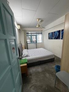 a bedroom with a bed and a table and a door at Stellas house in Langkawi Islands