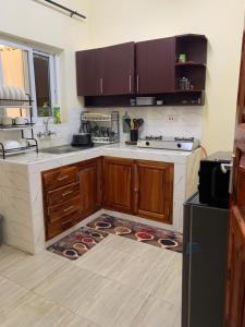 a kitchen with wooden cabinets and a counter top at Iconic lux living in Malindi +1 photo