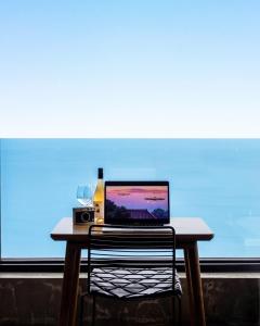 a table with a laptop and a bottle of wine at Samcheok Laon Spa Pension in Samcheok
