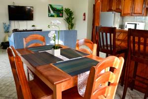 a wooden dining room table with chairs and a kitchen at EV's Place in San Ignacio +18 photos