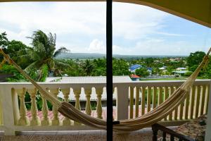 a hammock on the balcony of a house at EV's Place in San Ignacio
