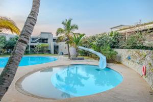 a swimming pool with a slide in a resort at Ocean Vista Pebble Beach in Umhlanga