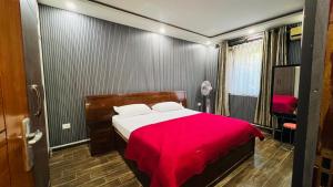 a bedroom with a bed with a red blanket at Borrow and Pay in Heṭauḍā
