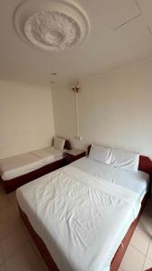a bedroom with two beds and a ceiling at Hotel CY in Sungai Besar