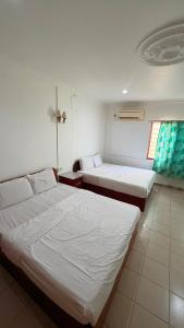 a hotel room with two beds and a window at Hotel CY in Sungai Besar
