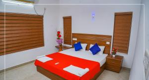 a bedroom with a red and white bed with blue pillows at Villas NEST Athirappilly in Athirappilly
