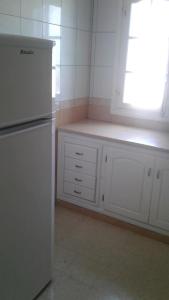 a kitchen with a white refrigerator and a window at maison djerbienne in Fafou