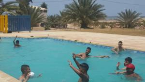 a group of boys playing in a swimming pool at maison djerbienne in Fafou