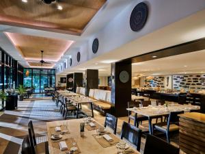 un restaurante con mesas y sillas en una habitación en Seda Lio El Nido Palawan, en El Nido