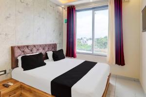 a bedroom with a large bed with a large window at Hotel manyam palace in Gorakhpur