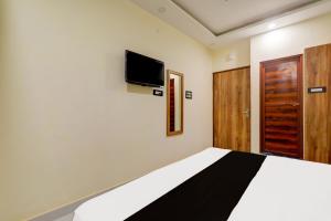 a bedroom with a bed and a tv on the wall at Hotel manyam palace in Gorakhpur +8 photos