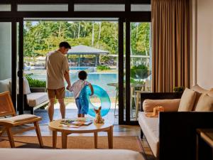 Un hombre y un niño de pie en una sala de estar. en Seda Lio El Nido Palawan, en El Nido