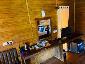 a room with a desk with a mirror and a bed at Habarana Tree House - Ivory cottage in Habarana