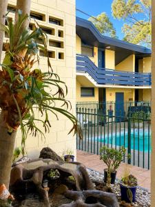 a building with a pool and some plants in front of it at Pathfinder Motel in Melbourne