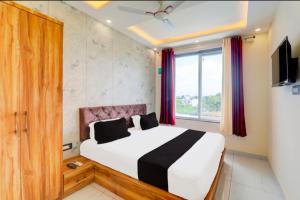 a bedroom with a bed and a large window at Hotel manyam palace in Gorakhpur