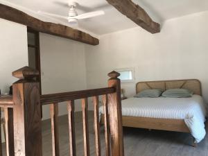 a bedroom with a bed and a wooden staircase at Pigeonnier La Carole 35m2 in Monlezun
