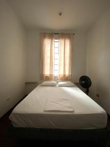 a bedroom with a large white bed with a window at Til Sunrise in Cali