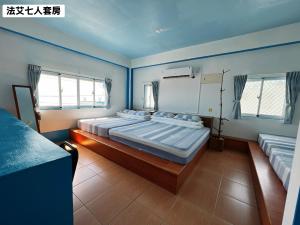 a bedroom with three beds in a room at 法艾民宿 in Yeh-yin