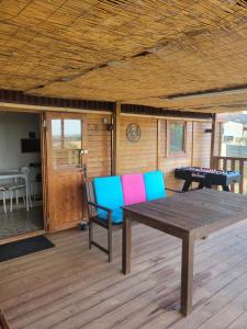a wooden deck with a table and a ping pong table at roulotte en bois in Ranton