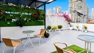 a rooftop patio with tables and chairs and flowers at Destiny Hostel Pattaya in Jomtien Beach
