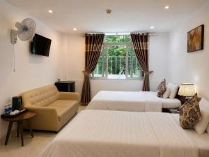 a hotel room with two beds and a couch at KHÁCH SẠN ROMO in Quảng Ngãi +169 photos