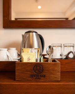 a wooden box sitting on a counter with a tea pot at River Bay Hotel in Pillagoda