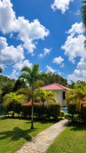 a house with a palm tree in a yard at River Bay Hotel in Pillagoda